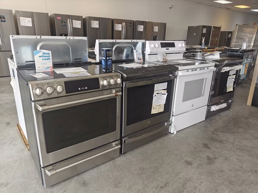 Stainless and white ranges with price sheets on the showroom floor